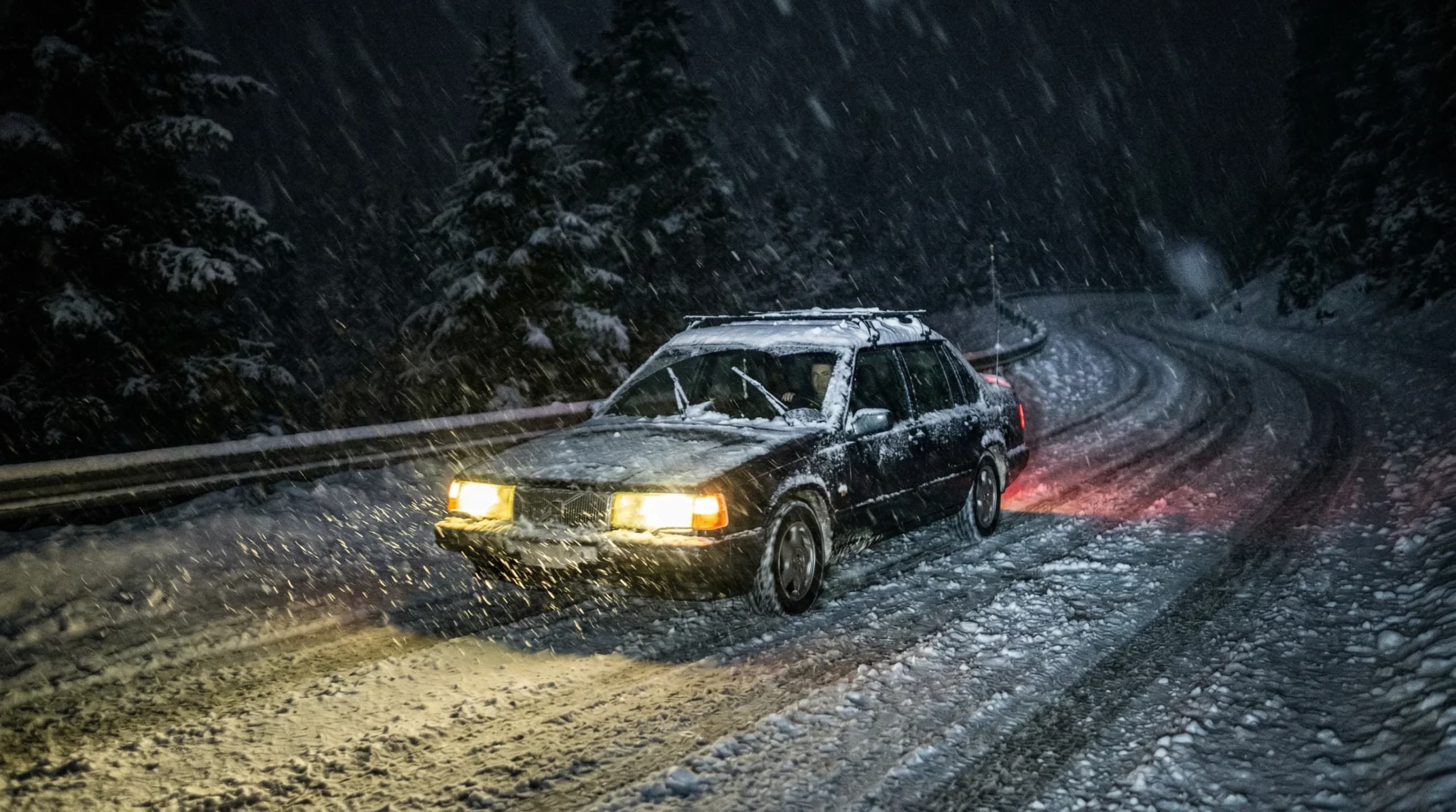 Voiture sur route enneigée de nuit